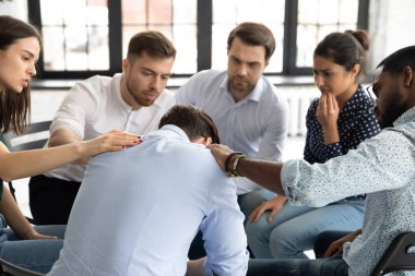 Çeşitli hastalar grup oturumunda üzgün adamı destekliyor