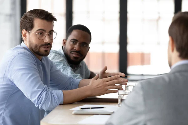 Des hommes d'affaires concentrés discutent de partenariat lors d'une réunion de bureau — Photo