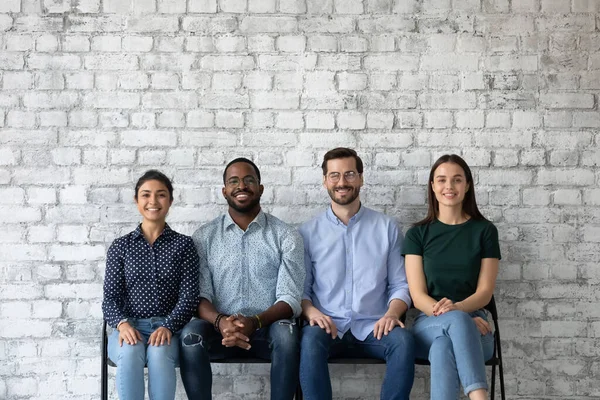 Smiling multiracial job candidates wait for interview in hallway