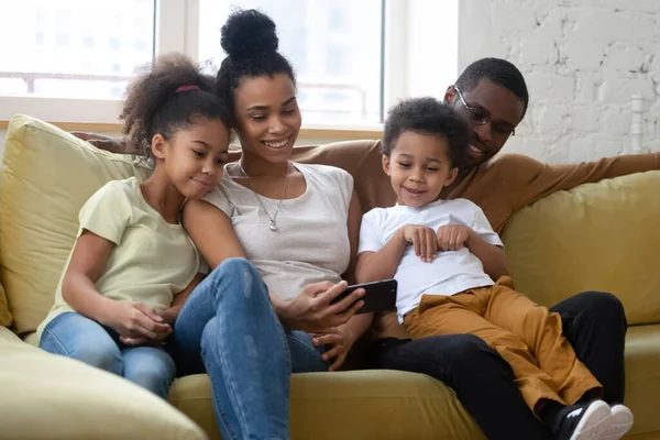 Famille afro-américaine souriante avec deux enfants qui passent un bon moment . — Photo