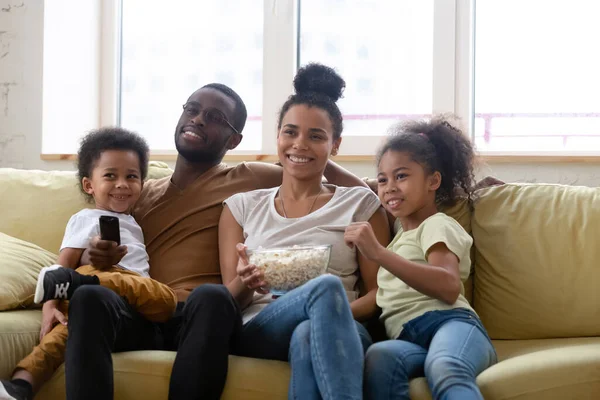 Glückliche afrikanisch-amerikanische Familie und Kinder sehen lustige TV-Show. — Stockfoto