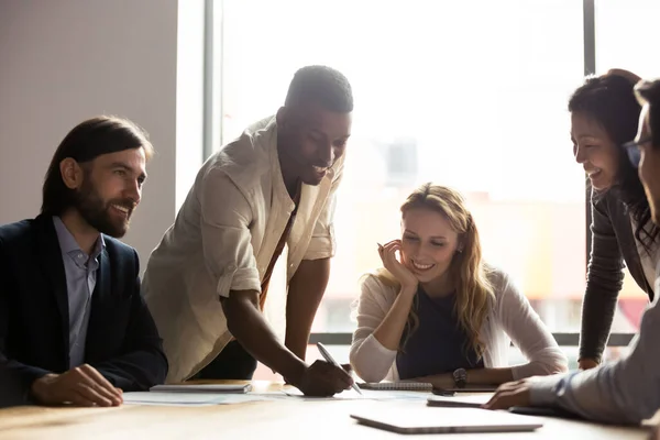 Sonrientes colegas multirraciales discuten el papeleo en la reunión — Foto de Stock