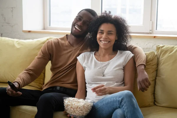 Joven feliz africano americano pareja viendo divertido programa de televisión . —  Fotos de Stock