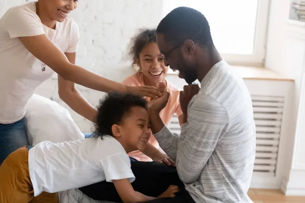 Feliz família afro-americana faz cócegas às crianças e diverte-se . — Fotografia de Stock