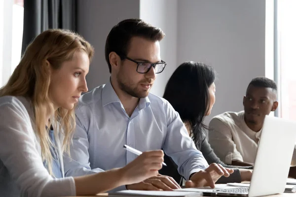 Colleghi focalizzati diversi lavorano sul brainstorming portatile al briefing insieme — Foto Stock