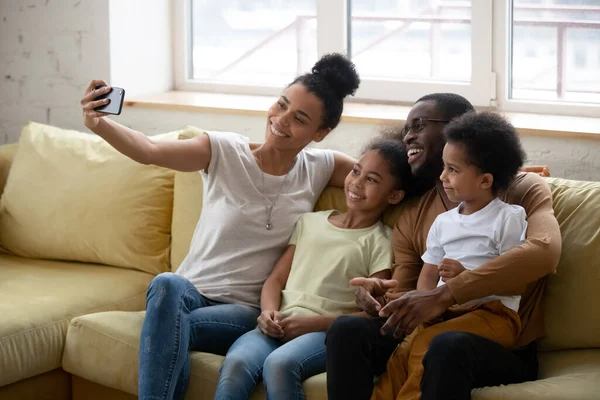 Parent afro-américain avec deux enfants prenant selfie . — Photo