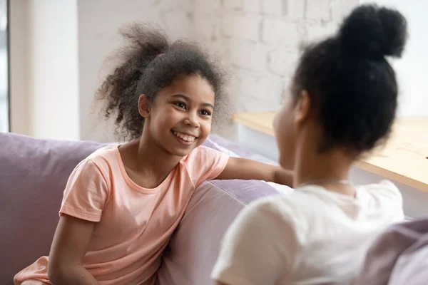 Africano americano linda hija sentado en sofá hablando con mamá . — Foto de Stock