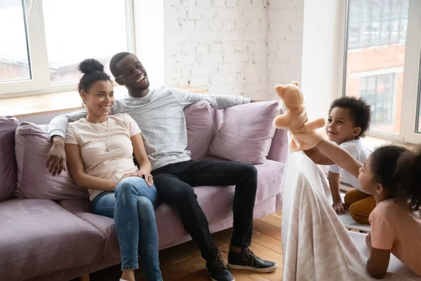 Feliz africano americano pareja viendo lindo hermanos títere espectáculo . — Foto de Stock