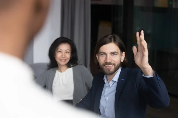 Motivated male employee raise hand ask question at meeting