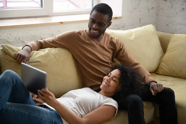 Joven pareja afroamericana feliz viendo en la pantalla de la tableta . —  Fotos de Stock