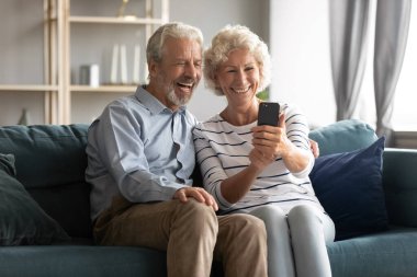 Heyecanlı, olgun bir çift telefonla eğleniyor.