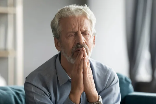 Close up sad mature man praying with hope alone — Stock Photo, Image