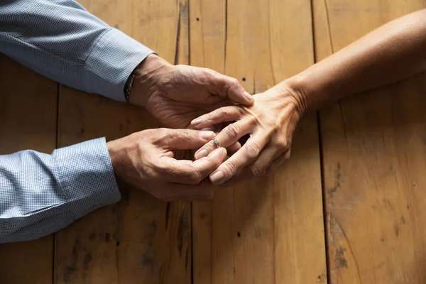 上了年纪的男人把订婚戒指戴在女人的手指上 — 图库照片