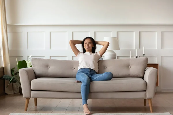 Asiatin ruht sich auf Couch aus und genießt zu Hause die frische Luft — Stockfoto