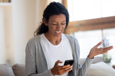 Kızgın Afrikalı kız akıllı telefon ekranına bak.