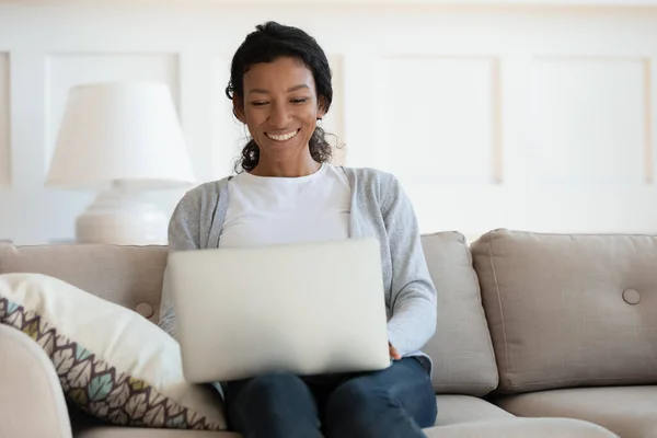 Sorrindo mulher africana olhando para a tela do laptop — Fotografia de Stock