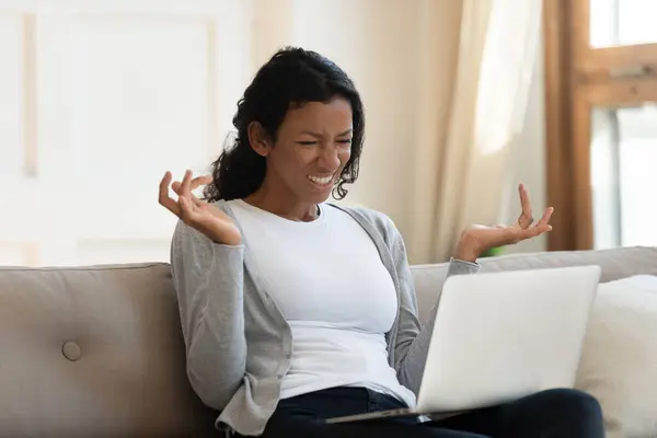 Muchacha negra joven molesta mirando la pantalla del ordenador portátil — Foto de Stock