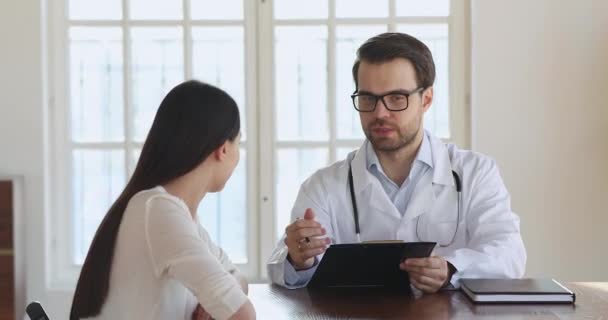 Professionell terapeut läkare som förklarar behandling på kliniken besök hos patienten. — Stockvideo