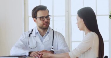 Profesyonel pratisyen hekim genç bir kadınla sağlık durumunu tartışıyor..