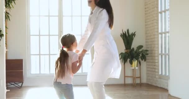Vtipné malé bezstarostné dítě dívka hrát baví s pediatrem. — Stock video