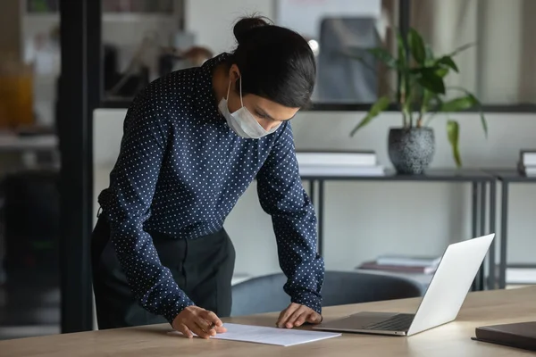 Female employee in face mask work in office — Stock Photo, Image