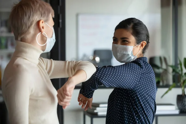 Diverse colleagues greeting touching elbows in office — Stock Photo, Image