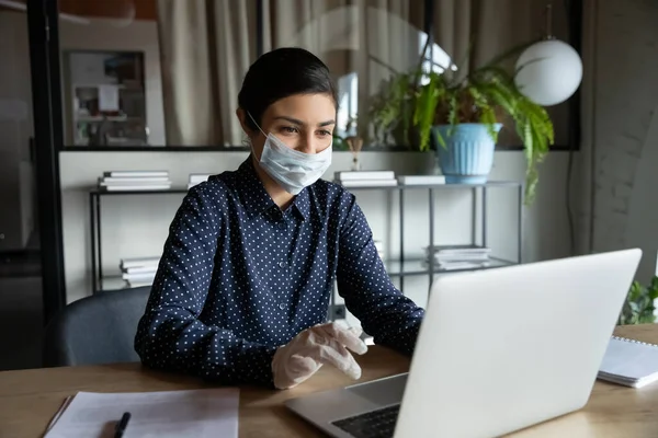 Empleada en máscara y guantes de goma trabajando en oficina — Foto de Stock