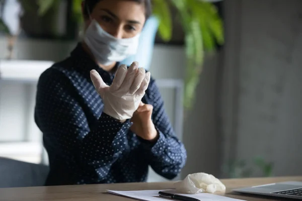 Female employee in face mask wear rubber gloves at workplace — Stock Photo, Image