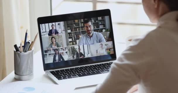 Over schouder zicht van de virtuele vergadering van de deelnemende groep van werknemers op afstand — Stockvideo
