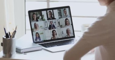 İş kadını uzaktan kumandalı video konferansında iş arkadaşlarını grup olarak görüntülüyorlar.