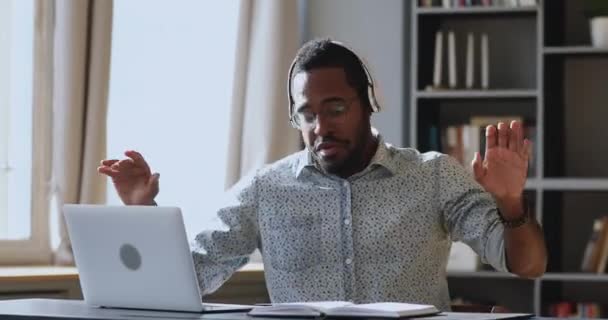 若いアフリカ系の男性従業員が精力的な音楽を聴く. — ストック動画