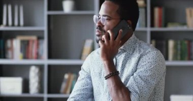 Gözlüklü, akıllı telefondan konuşan ciddi, Afrikalı, etnik bir adam..