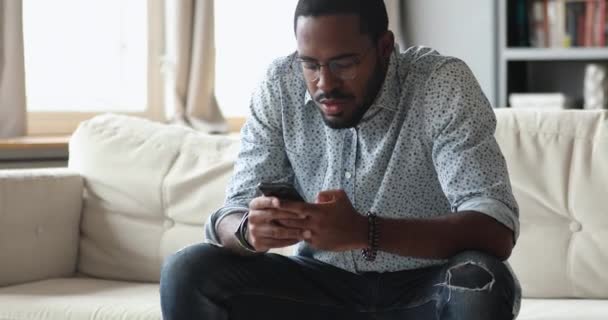 Focalisé jeune homme biracial en utilisant des applications mobiles sur le téléphone . — Video