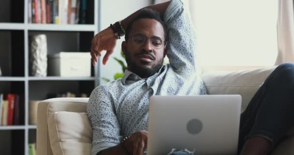 Glad ung afrikansk man chattar med vänner i sociala nätverk. — Stockvideo