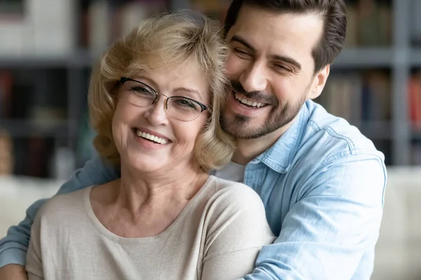 Grownup son hugs elderly mother laughing joking enjoy time together — Stock Photo, Image