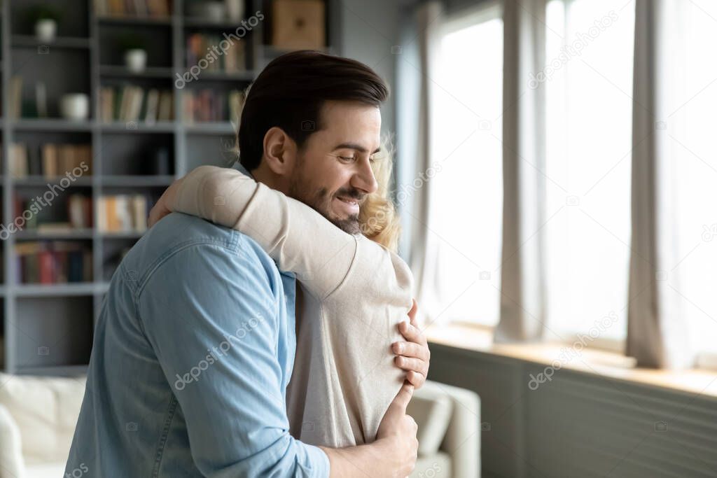 Adult son visited mother people hugging standing in living room