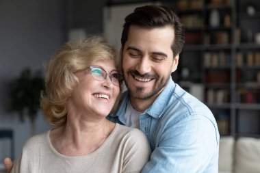 Yaşlı bir anne ve yetişkin bir oğul gülüyor. Birlikte iyi vakit geçirin.