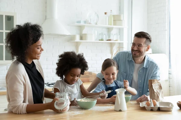 Vielrassige Familie mit Töchtern, die zu Hause gemeinsam backen — Stockfoto