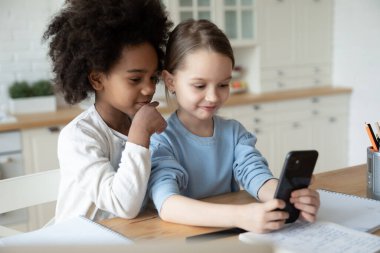 Evde cep telefonu kullanan çok ırklı küçük kızlar.