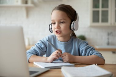 Küçük kız interneti kullanarak internetten ders çalışıyor.