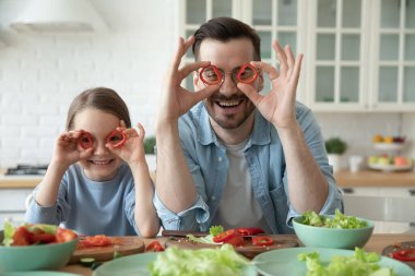 Gülümseyen küçük baba ve küçük kız birlikte yemek yaparken eğlenin.