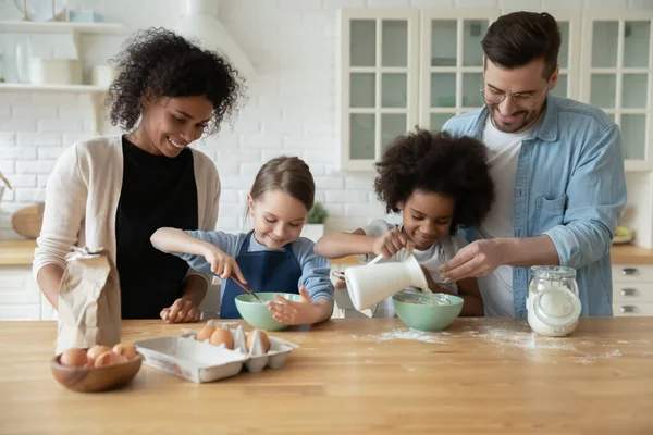 Çocukların birlikte yemek pişirdiği çok ırklı bir aile. — Stok fotoğraf