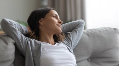 Kanepede dinlenen huzurlu bir kadın var.