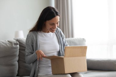 Mutlu güzel kadın karton kutuları boşaltan bir paket aldı.