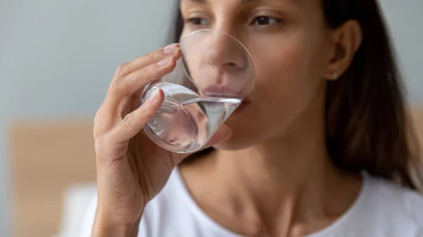 Chiudi bella giovane donna che beve acqua dal vetro — Foto Stock