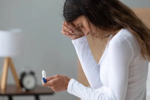 Ongelukkig gestresste vrouw die huilt, zich depressief voelt, zwangerschapstest houdt — Stockfoto