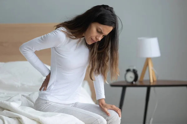 Mujer infeliz tocando músculos rígidos, sufriendo de dolor de espalda — Foto de Stock