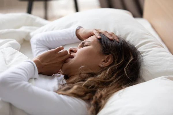 Close-up ongelukkige vrouw gevoel onwel, liggend in bed — Stockfoto