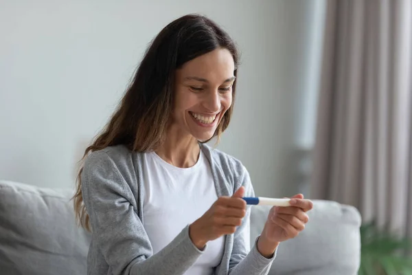 Vzrušená mladá žena spokojená pozitivním výsledkem těhotenského testu — Stock fotografie