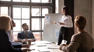 Toplantıda kendine güvenen genç bayan antrenör var.